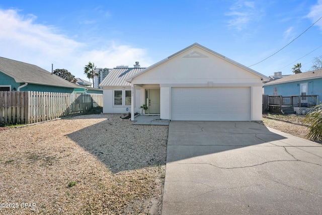 view of front of home with stucco siding, an attached garage, concrete driveway, and fence