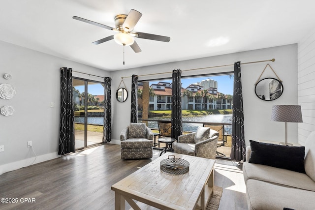 living room with ceiling fan, baseboards, a wealth of natural light, and wood finished floors