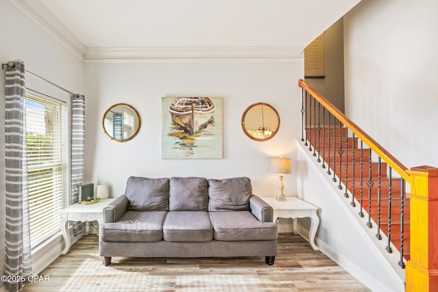 living room with baseboards, ornamental molding, stairs, and light wood finished floors