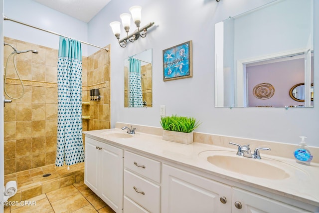 bathroom with double vanity, tiled shower, and a sink