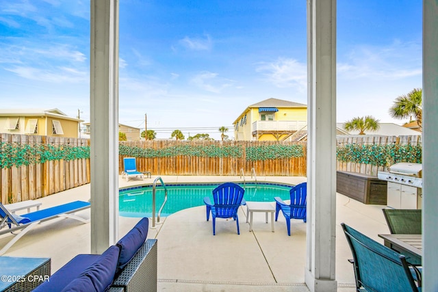 view of pool with grilling area, a fenced in pool, a fenced backyard, and a patio area