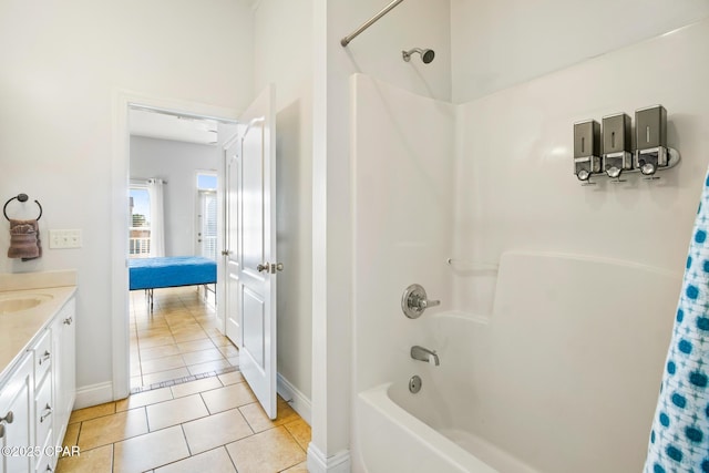 full bathroom featuring tile patterned flooring, vanity, baseboards, and shower / bath combo