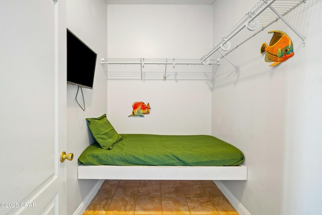 bedroom featuring tile patterned flooring and baseboards