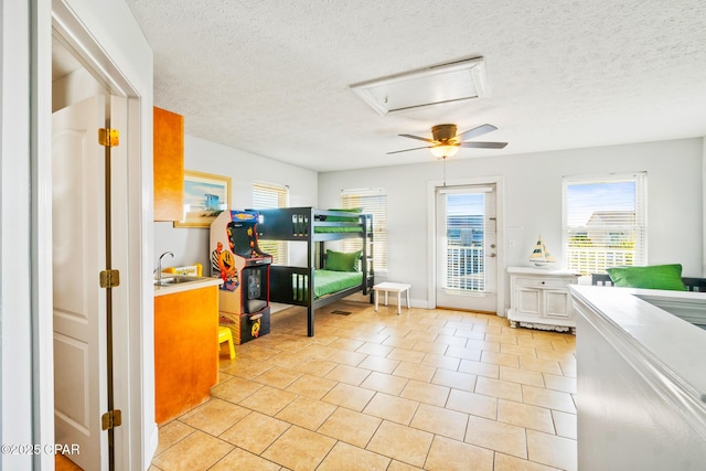 bedroom with access to exterior, light tile patterned flooring, a textured ceiling, and a sink