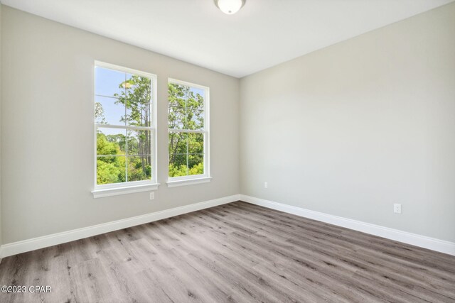 unfurnished room featuring baseboards and wood finished floors