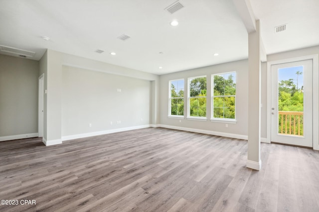 unfurnished living room featuring wood finished floors, recessed lighting, baseboards, and visible vents