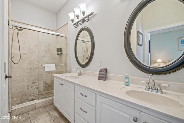 bathroom featuring a sink, tiled shower, double vanity, and tile patterned floors