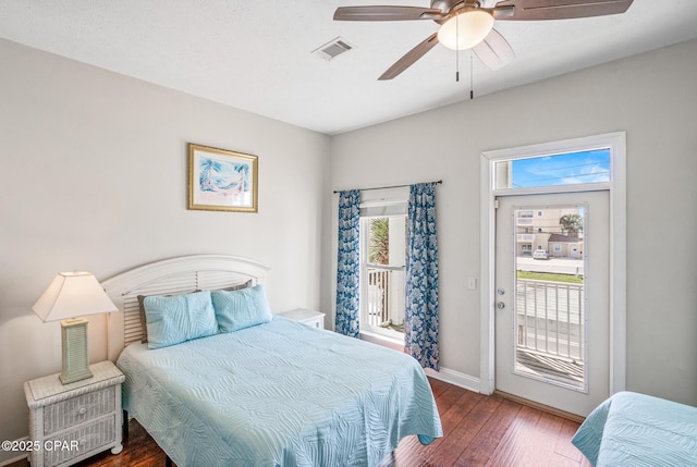 bedroom featuring a ceiling fan, wood finished floors, visible vents, baseboards, and access to outside