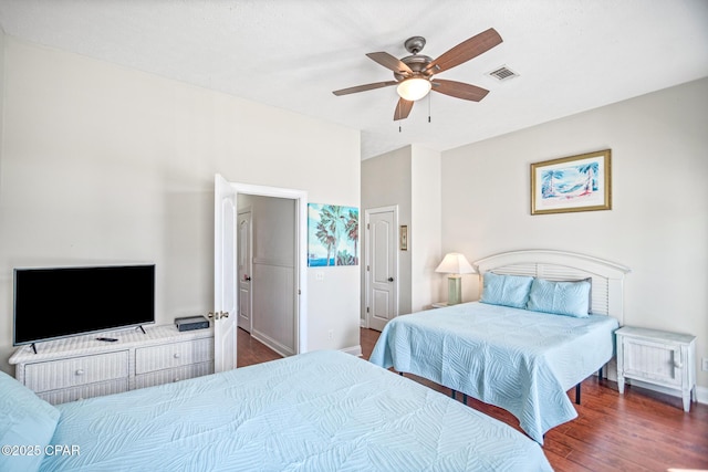 bedroom with ceiling fan, visible vents, baseboards, and wood finished floors