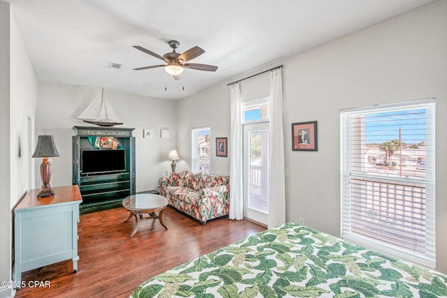 bedroom featuring visible vents, wood finished floors, a ceiling fan, and access to exterior