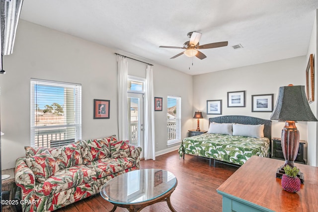 bedroom featuring visible vents, baseboards, hardwood / wood-style flooring, a ceiling fan, and access to outside