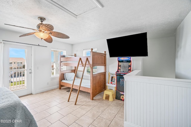 bedroom featuring access to exterior, light tile patterned floors, and a textured ceiling