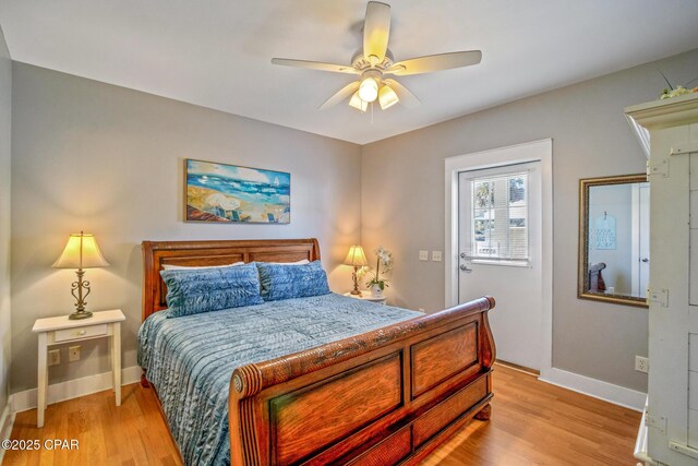 bedroom with light wood-style flooring, a ceiling fan, and baseboards