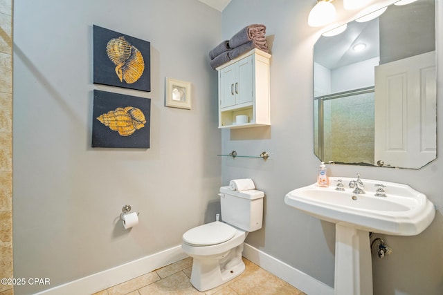 bathroom with tile patterned floors, baseboards, toilet, and a stall shower