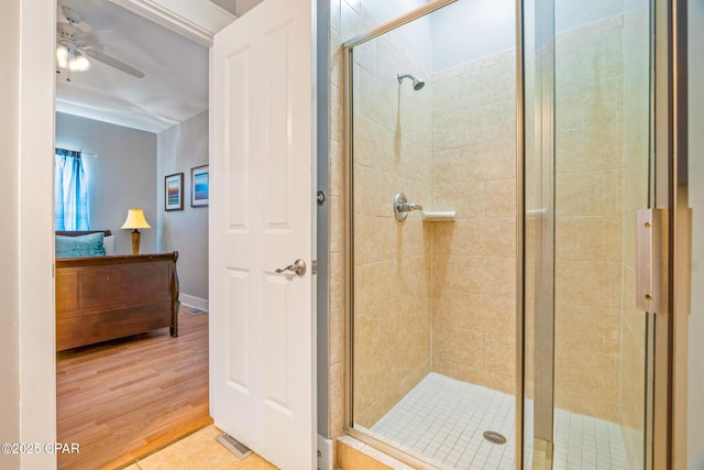 bathroom with visible vents, a ceiling fan, wood finished floors, and a shower stall