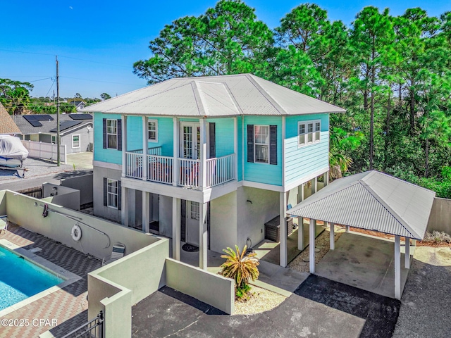 view of front facade featuring an outdoor pool, aphalt driveway, and fence private yard