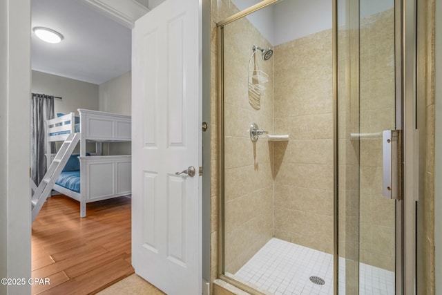 bathroom with a shower stall and wood finished floors