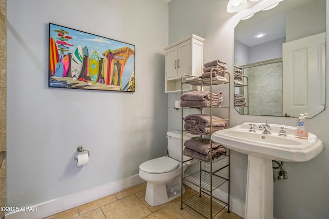 full bath featuring baseboards, toilet, a tile shower, tile patterned floors, and a sink