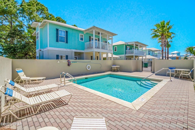 pool with a patio and fence