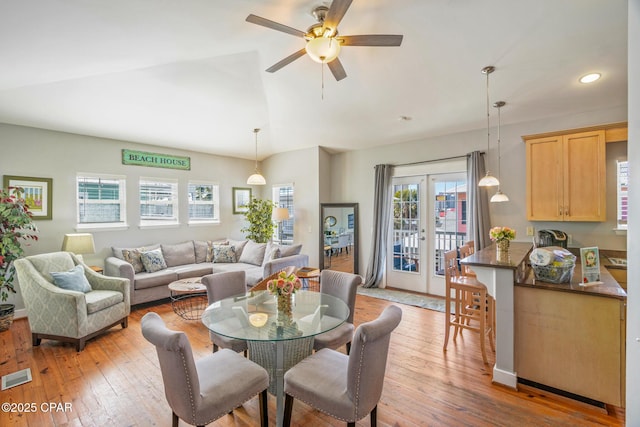 dining area featuring visible vents, ceiling fan, vaulted ceiling, light wood-style flooring, and french doors