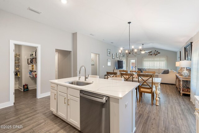 kitchen featuring wood finished floors, a sink, vaulted ceiling, stainless steel dishwasher, and open floor plan