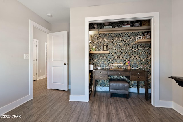 interior space with wallpapered walls, wood finished floors, and baseboards