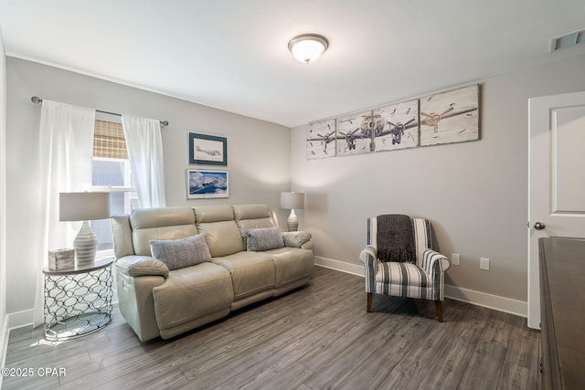 living room featuring wood finished floors, visible vents, and baseboards