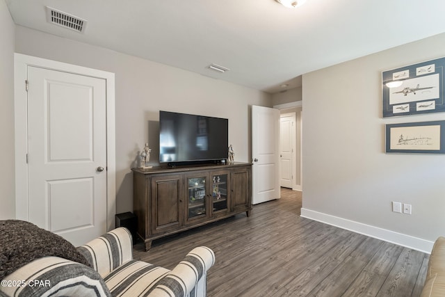 living room featuring visible vents, baseboards, and dark wood-style flooring