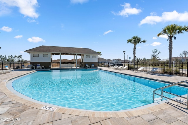 pool featuring an outbuilding, fence, and a patio area