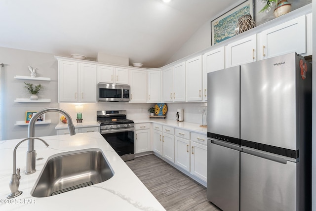 kitchen featuring a sink, open shelves, white cabinetry, and stainless steel appliances