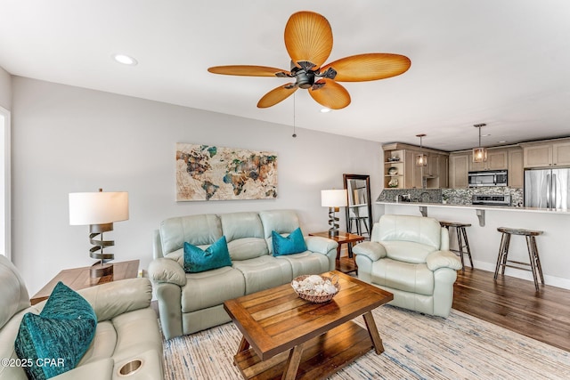 living room featuring ceiling fan, light wood-style flooring, and recessed lighting