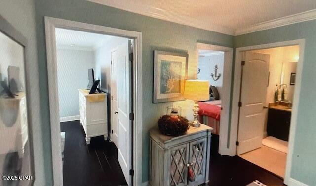 hall with dark wood finished floors, baseboards, and ornamental molding