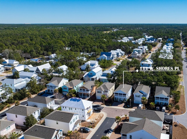 drone / aerial view featuring a residential view and a wooded view