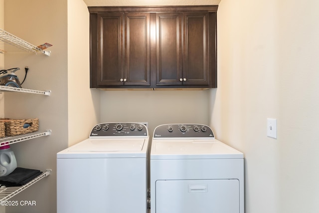washroom with cabinet space and washer and clothes dryer