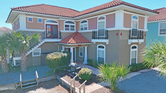 mediterranean / spanish house with stucco siding and a tiled roof