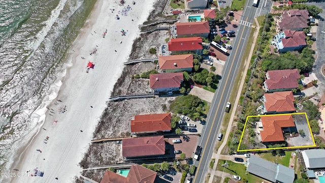 aerial view featuring a view of the beach, a water view, and a residential view