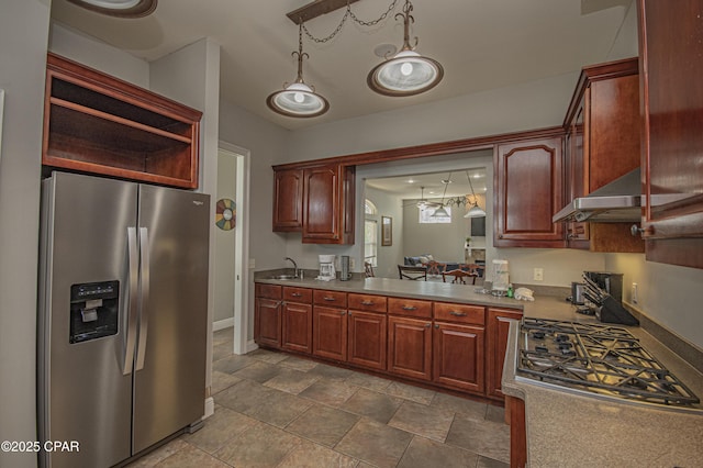 kitchen featuring decorative light fixtures, stainless steel appliances, light countertops, and a sink