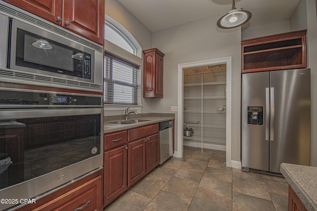 kitchen with a sink, open shelves, stainless steel appliances, reddish brown cabinets, and baseboards