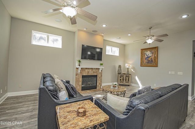 living area with a fireplace, wood finished floors, and baseboards