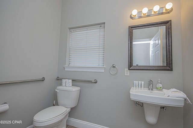 bathroom with toilet and baseboards