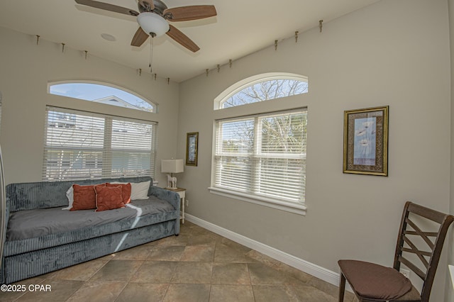 sitting room featuring a ceiling fan and baseboards