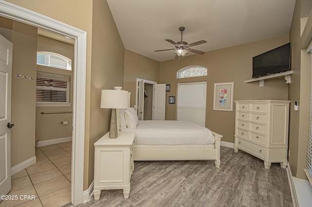 bedroom with multiple windows, light wood-style flooring, and baseboards