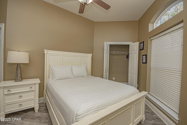 bedroom with dark wood-type flooring, baseboards, a closet, and ceiling fan