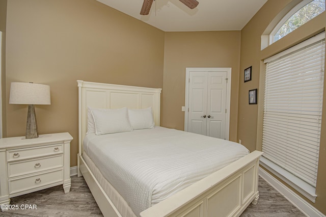 bedroom with ceiling fan, baseboards, and wood finished floors