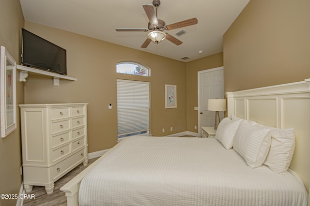 bedroom featuring a ceiling fan, wood finished floors, visible vents, and baseboards