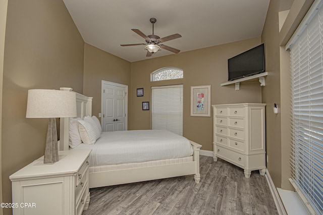 bedroom with wood finished floors, baseboards, and ceiling fan