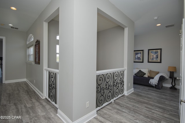 corridor featuring recessed lighting, baseboards, and wood finished floors