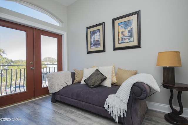 living room featuring french doors, baseboards, and wood finished floors