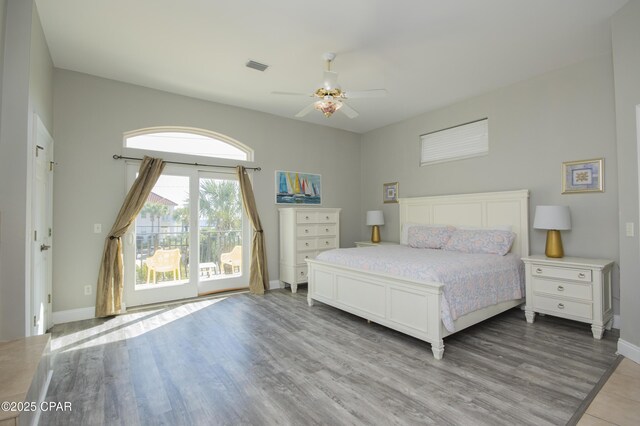 bedroom featuring access to outside, wood finished floors, visible vents, and ceiling fan