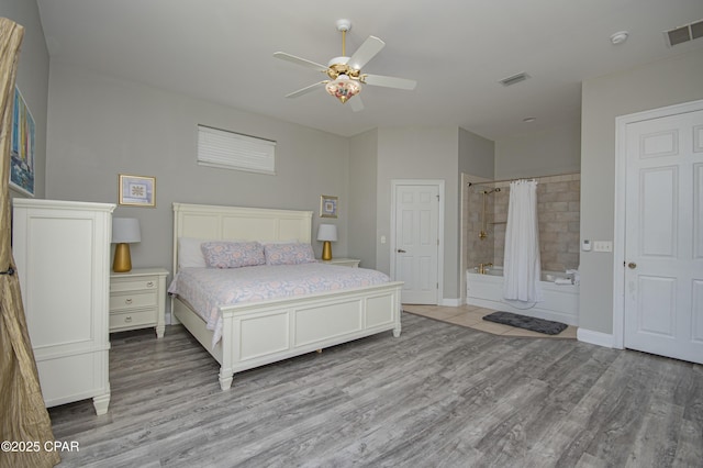 bedroom with baseboards, visible vents, light wood finished floors, and ceiling fan